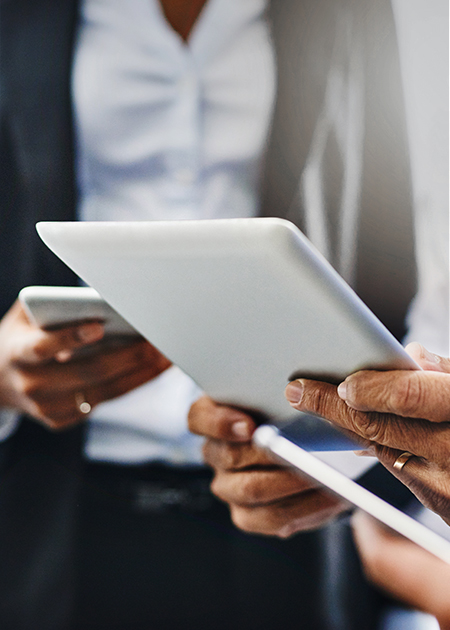 Two advisors review information technology strategies on a phone and tablet